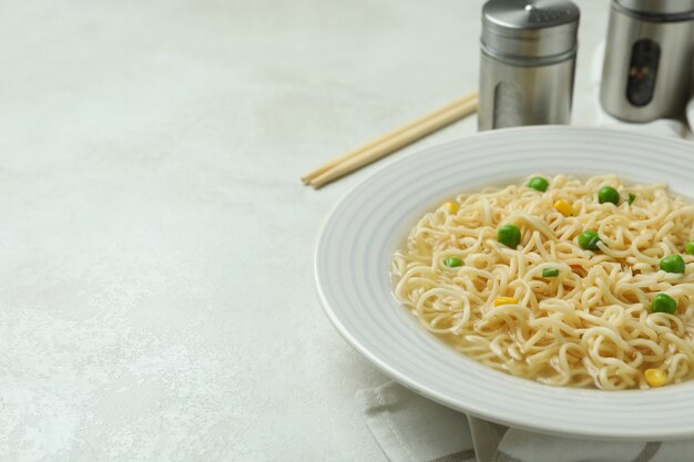 Concept of breakfast with plate of noodles on white textured