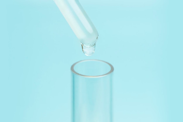 The concept of the chemical industry and work in the laboratory Liquid drop from laboratory glass pipette to test tube