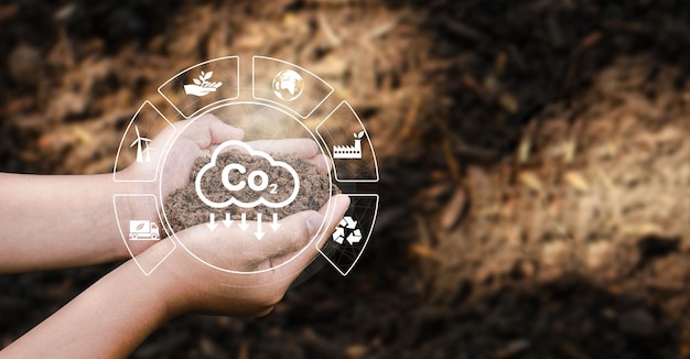 The concept of CO2 emissions in the hands of planting soil for the environment Carbon dioxide emissions global warming sustainable development and environmental business from renewable energy