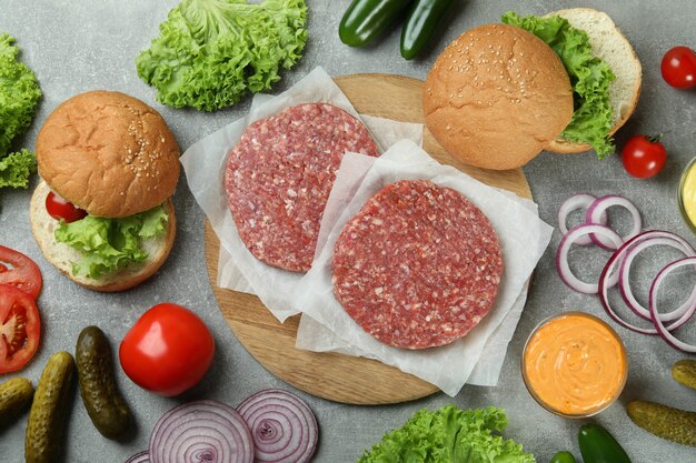 Concept of cooking burger on gray textured table