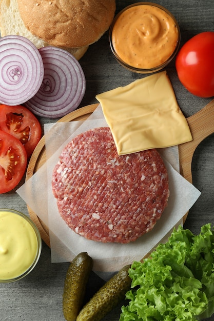 Concept of cooking burger on gray textured table