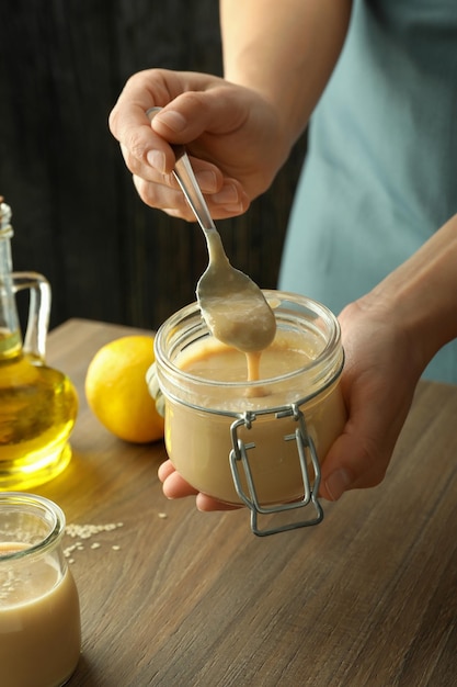 Concept of cooking tasty food with tahini sauce on wooden table