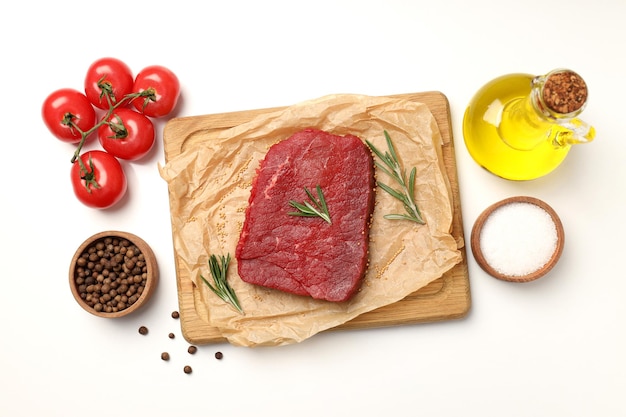 Concept of cooking with raw beef steak on white background