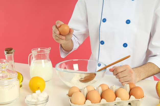 Concept of cooking young chef cook something on pink background