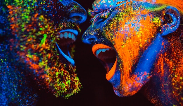 Concept. Couple smiling. Portrait of a pair of lovers painted in fluorescent powder.