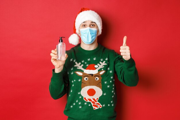 Concept of covid-19 and Christmas holidays with handsome young man wearing a mask