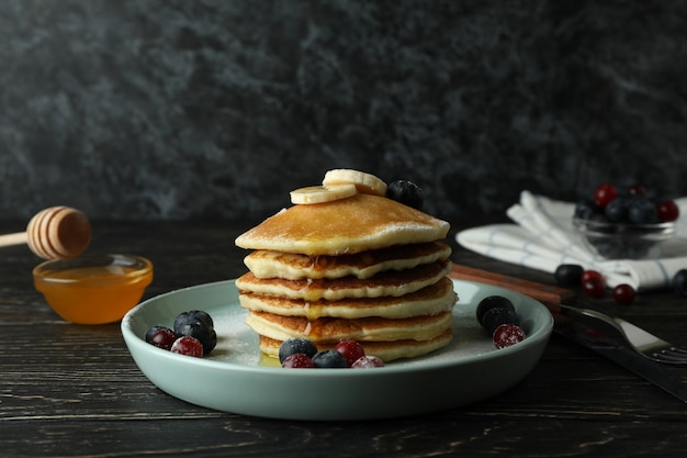 Concept of delicious dessert with pancakes on wooden table