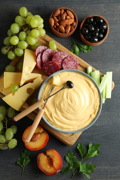 Concept of delicious food with fondue on dark wooden table