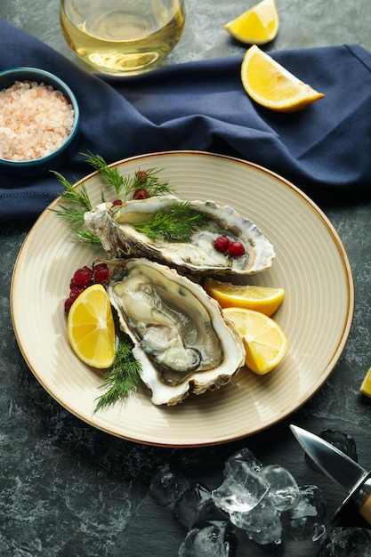 Concept of delicious seafood oysters on black smoky table