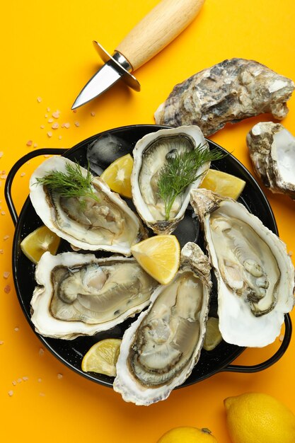 Concept of delicious seafood oysters on orange background