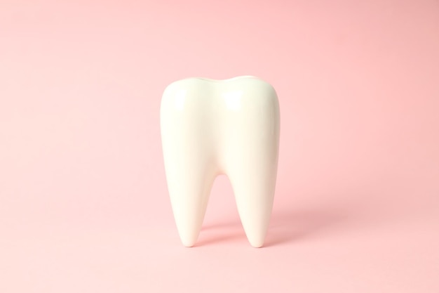 Concept of dental care tooth on pink background