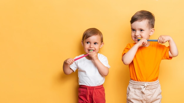 The concept of dental hygiene. Brother and sister brush their teeth together with a toothbrush. Space for the text. Prevention of caries