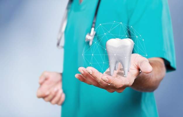 The concept of dental treatment. Doctor shows a tooth in his hand.