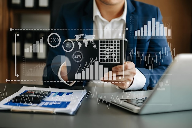 Concept of digital diagramgraph interfacesvirtual icon Team of business analysts discussing the business strategy in contemporary using on smartphone and tablet with startup project in officexAxA