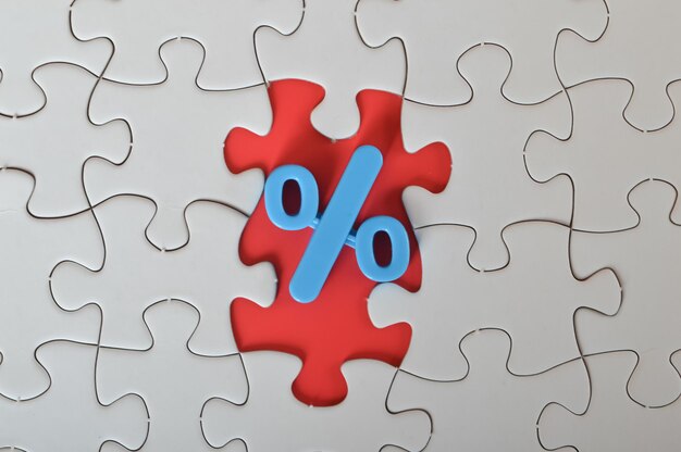 Photo concept of discounted selling and a big sale through jigsaw puzzle that features a percentage symbol