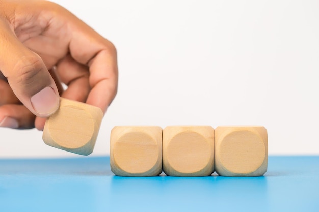 Concept of education and development Hand picking blank wooden cube block sort on table use for create text or symbol growth success