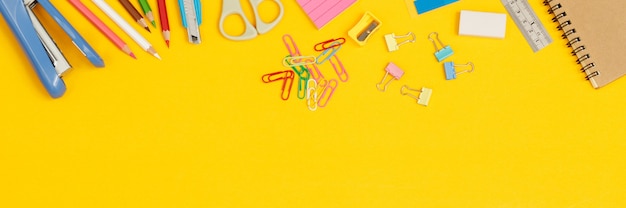 Concept of education top view notebooks and accessories stationery in the library at school yellow background