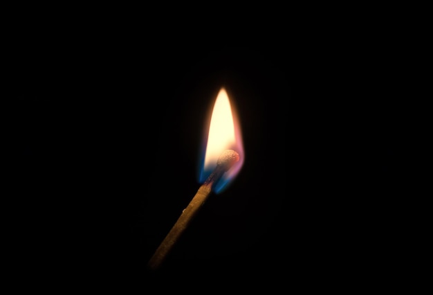 Concept of fire and arson. Burning match on a black background