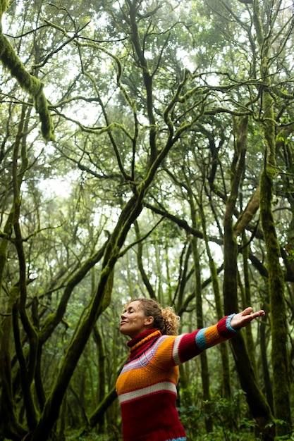 Concept of freedom and protection of forest in earth's day Standing woman with closed eyes enjoy feeling with forest and trees around Mindufulness exercise female adult Positive moment with nature