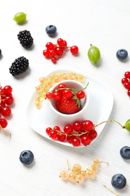 Concept of fresh food on white wooden background berries