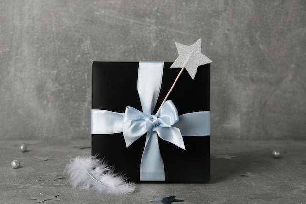 Concept of gift on gray textured table black gift box