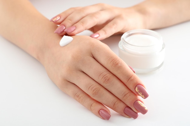 Concept of hand care with cosmetics on white background