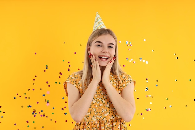 Concept of Happy Birthday with young woman on yellow background