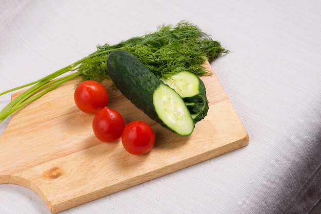 Concept of healthy eating. Cucumber and cherry tomatoes on Board