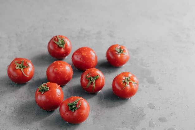 Concept of healthy eating Fresh red tomatoes with rain drops for making delicious vegetarian meal Close up shot Wet vegetables