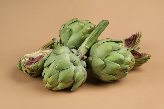 Concept of healthy food with artichoke on light brown background