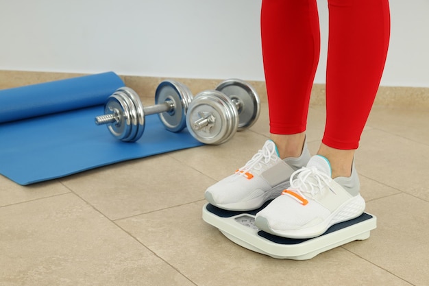 Concept of healthy lifestyle with woman stands on scales