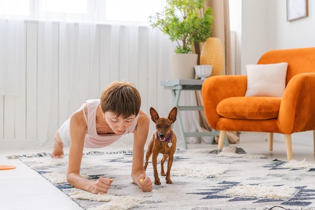 Concept healthy lifestyle Yoga and fitness Cute woman with small dog