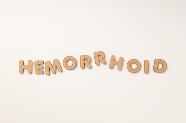 Concept of hemorrhoids with wooden letters on white background