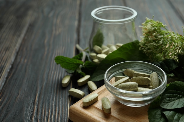 Concept of herbal medicine pills on wooden table