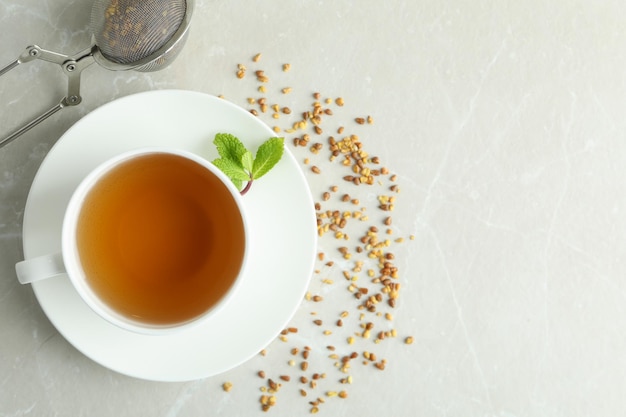 Concept of hot drink with buckwheat tea on light textured table