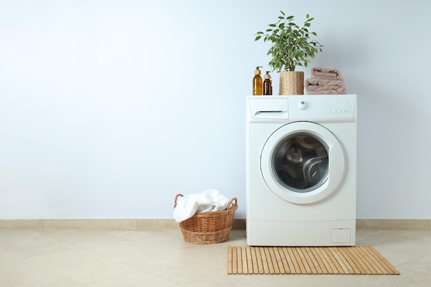 Concept of housework with washing machine against white wall