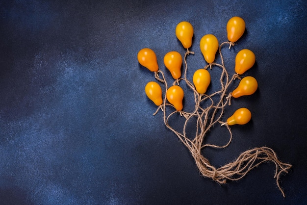 The concept idea in the form of balloons on ropes is made of yellow tomatoes