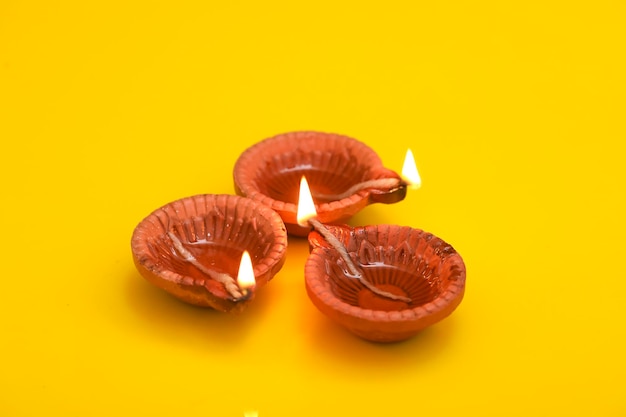 Concept of indian festival diwali Traditional oil lamps on yellow background