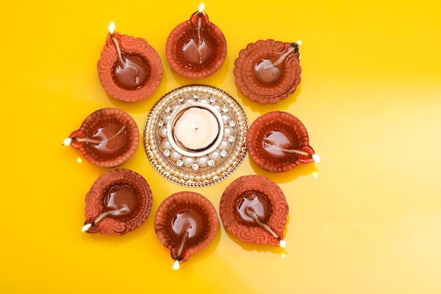 Concept of indian festival diwali Traditional oil lamps on yellow background