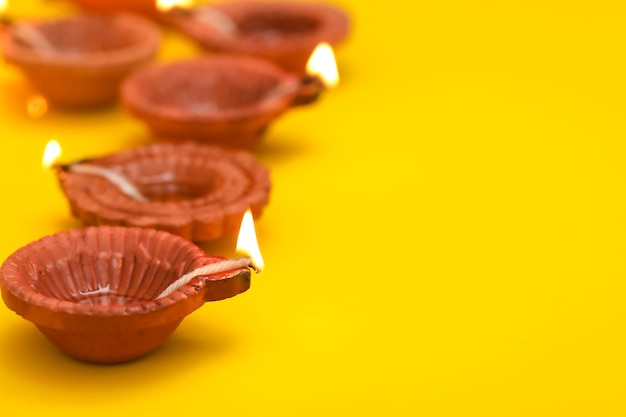 Concept of indian festival diwali Traditional oil lamps on yellow background