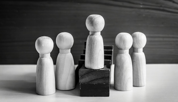 Photo concept of leadership wooden dolls on black and white background