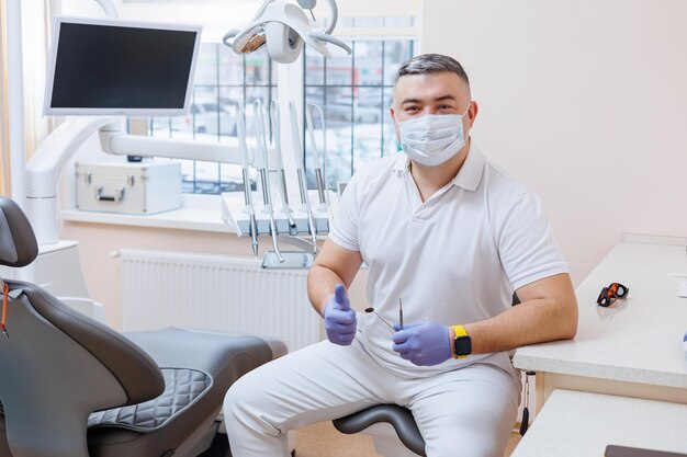 The concept of medicine profession dentistry and medicine  a smiling middleaged dentist on the background of a medical office The dentist is in his dental office