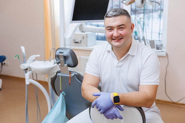 The concept of medicine profession dentistry and medicine  a smiling middleaged dentist on the background of a medical office The dentist is in his dental office