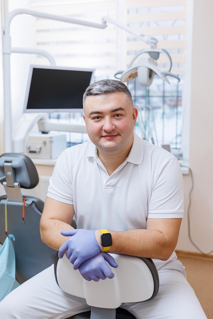 The concept of medicine profession dentistry and medicine  a smiling middleaged dentist on the background of a medical office The dentist is in his dental office