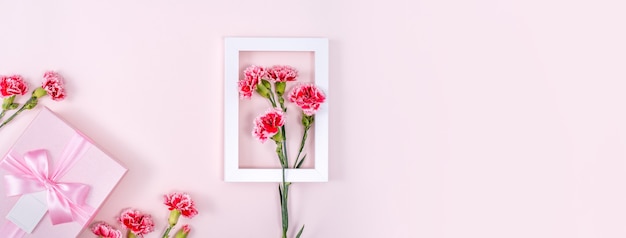 Concept of Mother's day holiday greeting background design  with carnations bouquet on pink background