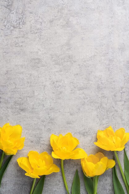 Concept of Mother's day holiday greeting design with yellow tulip flower bouquet on gray background