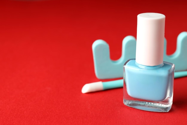 Concept of nail care with manicure accessories on red background