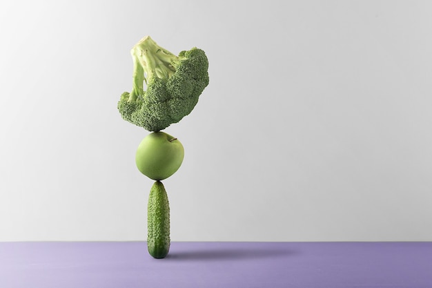 Concept of nutritional balance. Fresh fruits and vegetables are balanced against a gray background.