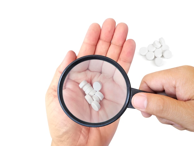 Concept pharmaceutical testing drug testing magnifying glass pills on a white background