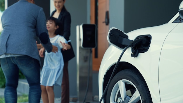 Concept of a progressive family with a home charging station for an electric vehicle encouraging healthy and clean environment The electric vehicle powered by sustainable clean energy technology